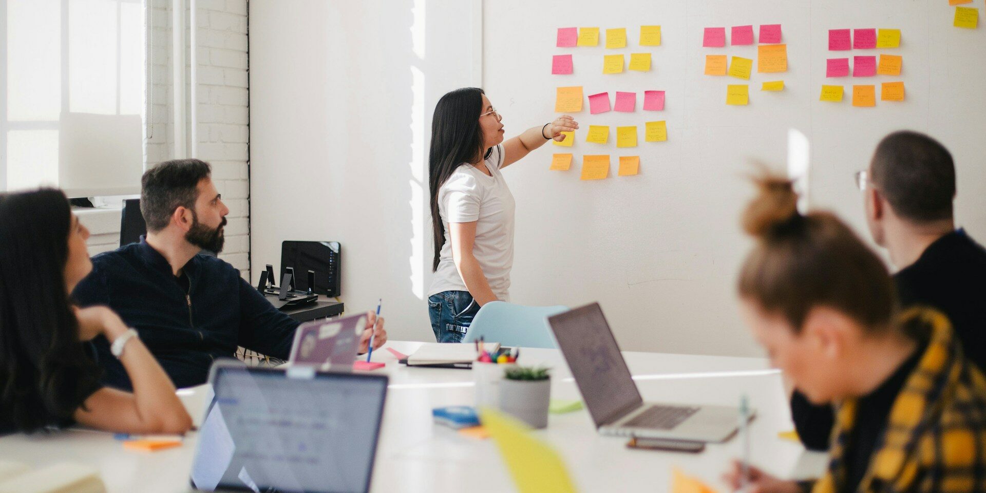 woman at wall with post-it for a web designer meeting