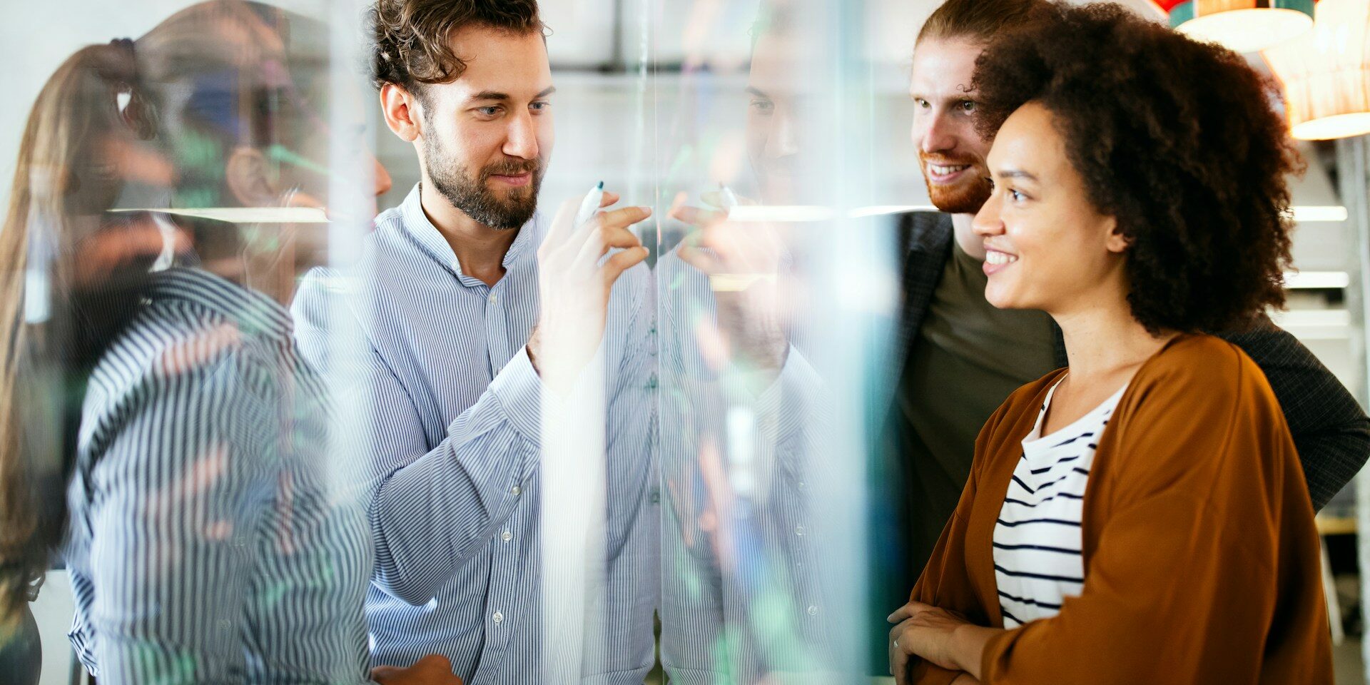 group of professionals around a clear white board