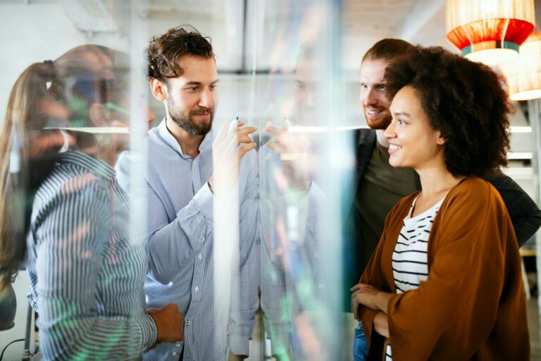 group of professionals around a clear white board