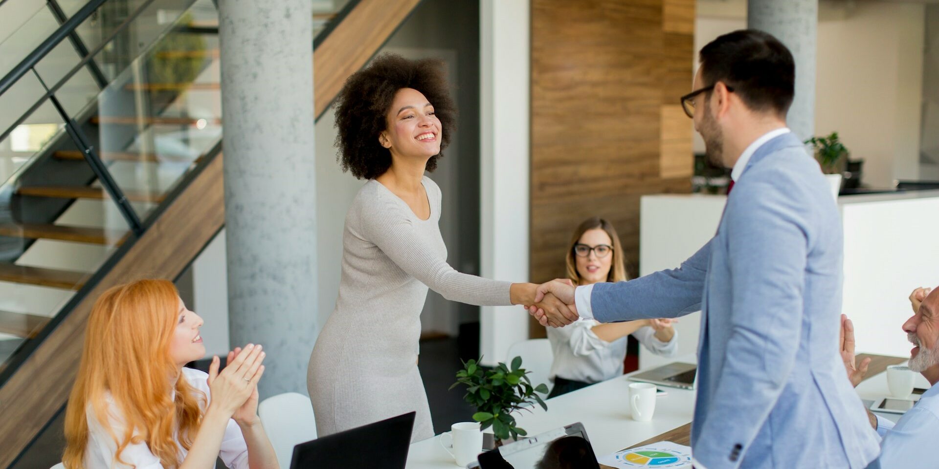 two professionals shaking hands as if in a meeting asking the top 10 questions to ask any embedded teams vendor