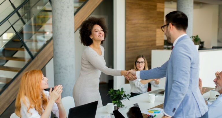 two professionals shaking hands as if in a meeting asking the top 10 questions to ask any embedded teams vendor