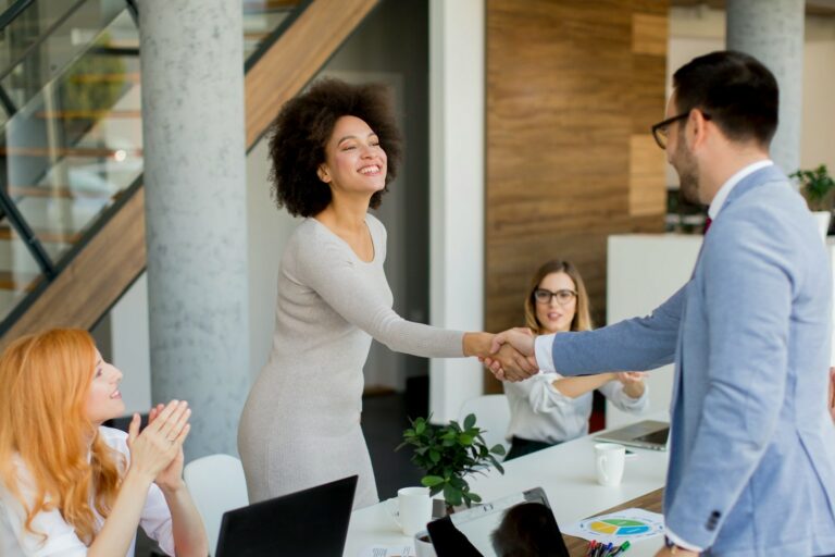 two professionals shaking hands as if in a meeting asking the top 10 questions to ask any embedded teams vendor